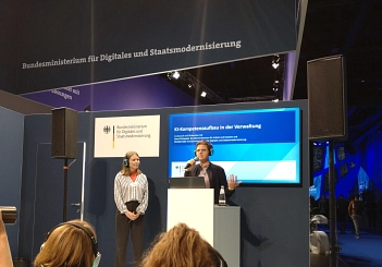Smart Country Convention 2025 Eine Bühne mit 2 Menschen, im Hintergrund eine Präsentationsfolie vom Bundesministerium für Digitales und Staatsmodernisierung. © Stadt Göttingen